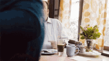 a man is sitting at a table with a plate of food and a glass of beer .