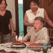 an elderly woman blowing out candles on a birthday cake with the caption happy 50th