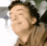 a blurry picture of a man 's face with his eyes closed .