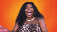 a woman in a leopard print dress is making a funny face .