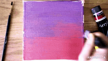 a bottle of acrylic paint is next to a brush