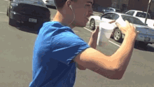 a man wearing ear buds is drinking from a cup