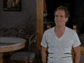 a man in a white t-shirt is sitting in a chair