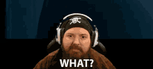 a man with a beard wearing headphones and a bandana that says what