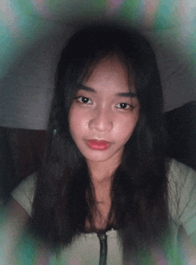 a young woman with long black hair and red lips looks at the camera