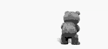 a teddy bear is standing in front of a white background holding a bottle .