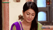 a woman is sitting in front of a star plus hd television