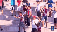 a crowd of people watching a soccer game with the scoreboard showing sal 1 0 nau