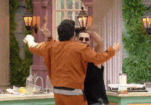 a man in an orange jacket is dancing with another man