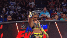 a female wrestler is standing in front of a sign that says w on it