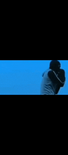 a person in a blue shirt is standing in the dark