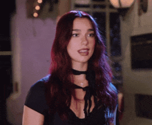 a woman with red hair is wearing a black choker necklace