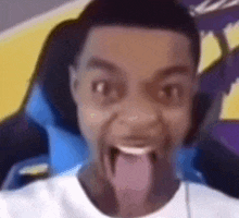 a man is sitting in a chair with his tongue sticking out .