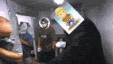 a man with a picture of lucas on his head stands in a room with other men