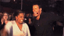 a man and woman are dancing in front of a crowd