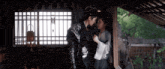 a man and a woman are standing next to each other in a room and looking at each other .