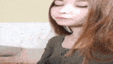 a woman with long red hair is making a funny face with her eyes closed .