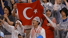 a group of people holding a flag with a crescent moon and star on it