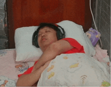 a man wearing headphones sleeps on a bed