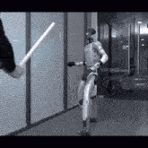 a robot is standing in a hallway with a person holding a stick in front of it