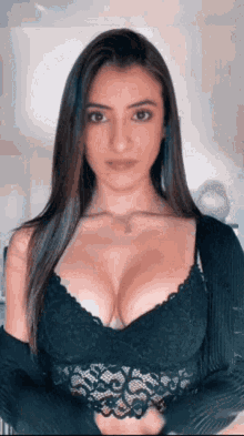 the woman is wearing a black lace top and a black cardigan .