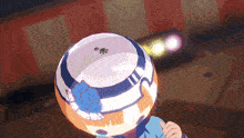 a person wearing a hat with a paw print on it holds a ball in front of their head