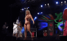 a group of women are dancing on a stage with a speaker in the background
