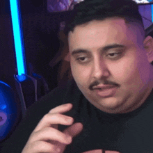 a man with a mustache is making a funny face with his eyes closed .
