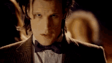 a close up of a man wearing a suit and bow tie .