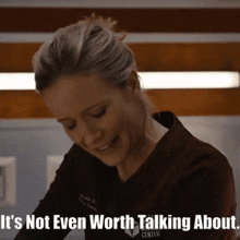 a woman says it 's not even worth talking about while smiling