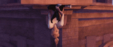 a man is hanging upside down under a sign that says give way all