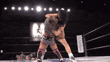 two women wrestling in a ring with a softbank sign behind them