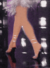 a woman wearing a purple dress and clear heels