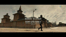 a man is walking in front of a building that says kamal haasan sony pictures