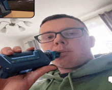 a man wearing glasses is smoking a electronic cigarette .