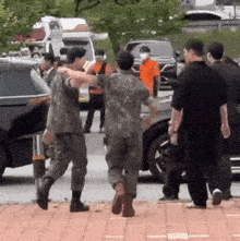 a group of soldiers are hugging each other on a street .