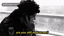 a man is talking on a cell phone while looking out of a window .