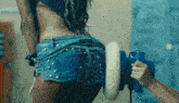 a woman in denim shorts is being polished by a person