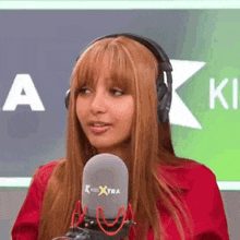 a woman wearing headphones is sitting in front of a microphone .