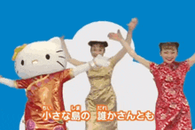 a hello kitty mascot is dancing with two women in red dresses