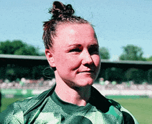 a woman with a bun on her head is wearing a green nike jersey