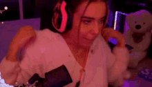 a woman wearing headphones is standing in front of a microphone in a room .