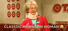 an elderly woman wearing a neck brace and a red jacket is laughing in front of a target sign .