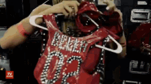 a woman is holding a red vest that says broken 00 on it