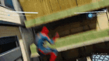 spider-man is flying through the air in a video game while jumping over a building .