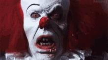 a close up of a scary clown with a bloody nose .
