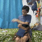 a man is sitting on a bed with a backpack on the wall