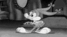 a black and white cartoon of mickey mouse is dancing in a room .