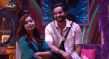 a man and a woman are sitting next to each other on a stage .