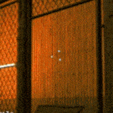 a wooden door with a chain link fence around it
